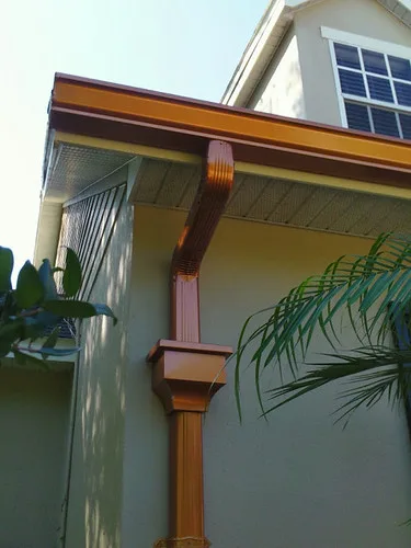 Close-up of a gutter hanger being screwed into a fascia board