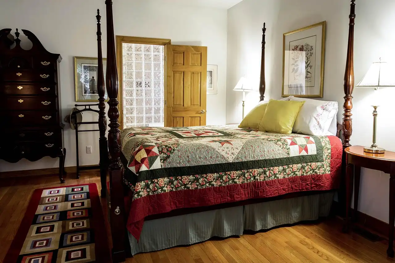 Homeowner lifts an area rug corner to inspect the rug pad and hardwood floor beneath.
