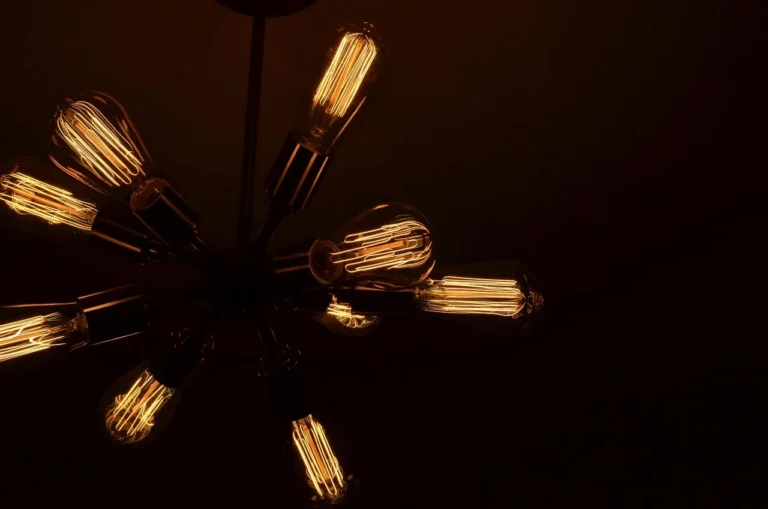 Glowing Edison bulbs on a ceiling light fixture against a dark background