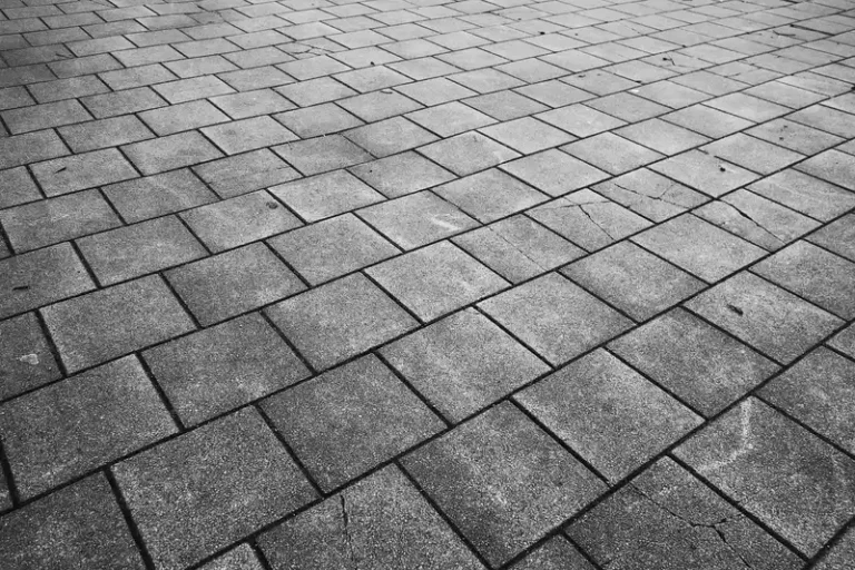 Gray stone pavers laid in a diagonal pattern on a paved surface