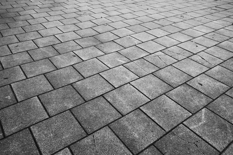 Gray stone pavers laid in a diagonal pattern on a paved surface