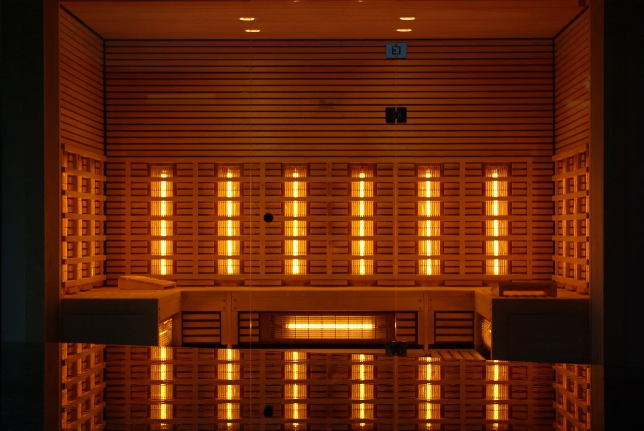 A drafty living room with a panel heater, an infrared heater, and a person comparing warmth.