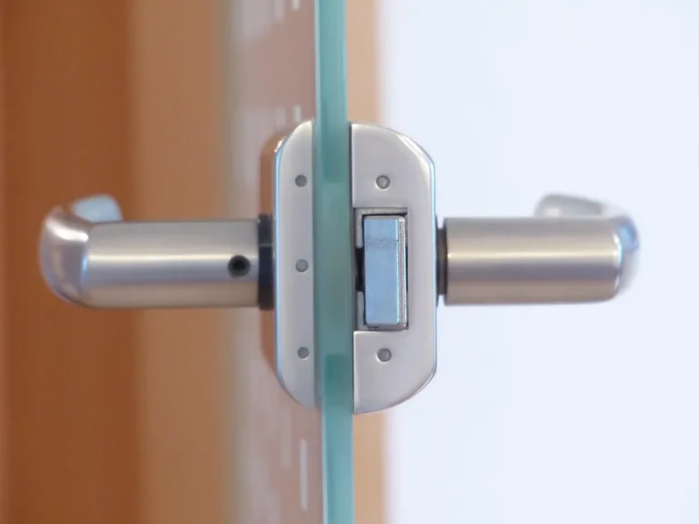 Person comparing a door knob, latch, and tape measure on a workbench