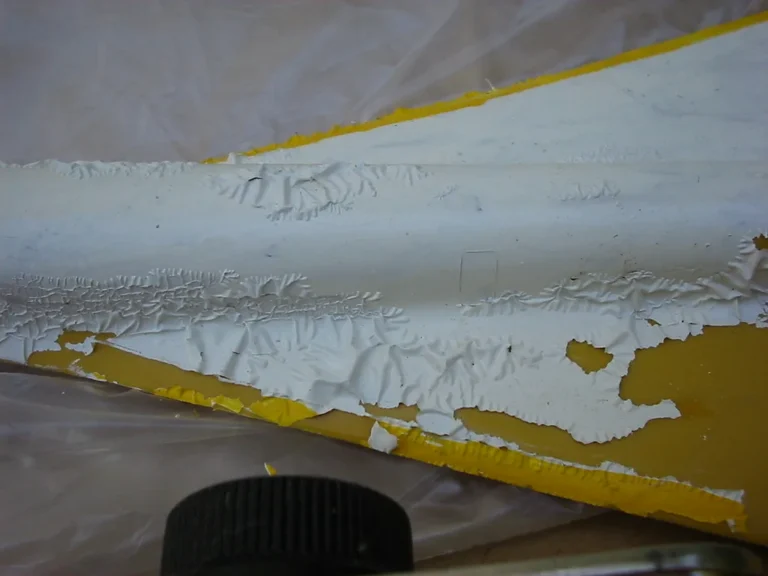 Paint removal tools and sample surfaces on a sunlit workbench