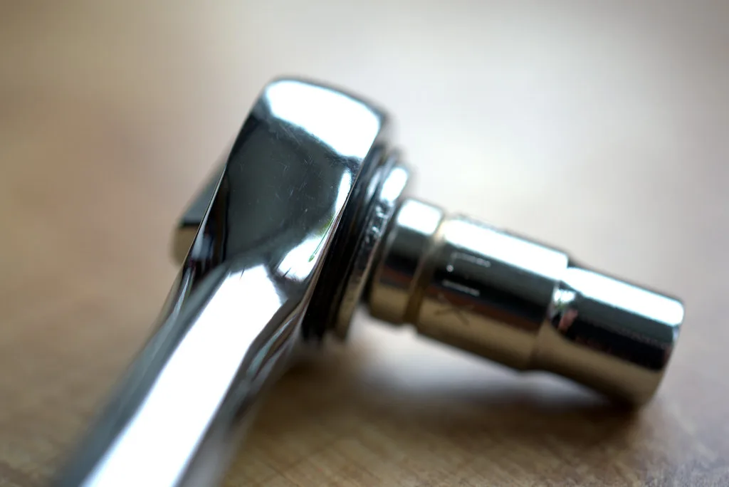 Close-up of a ratchet tool engaged on a fastener with the directional switch visible