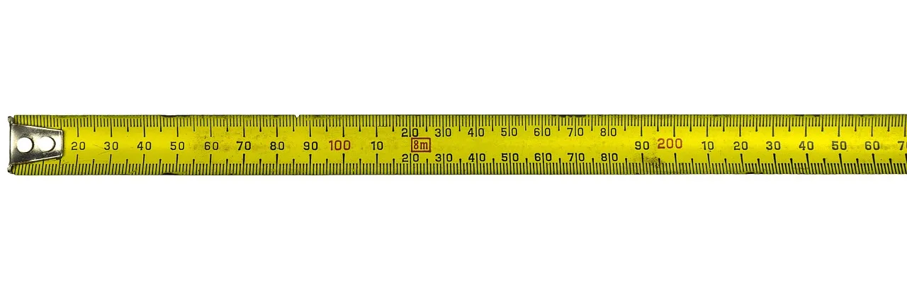 Homeowner and contractor measuring a living room wall with a tape measure near a doorway and window