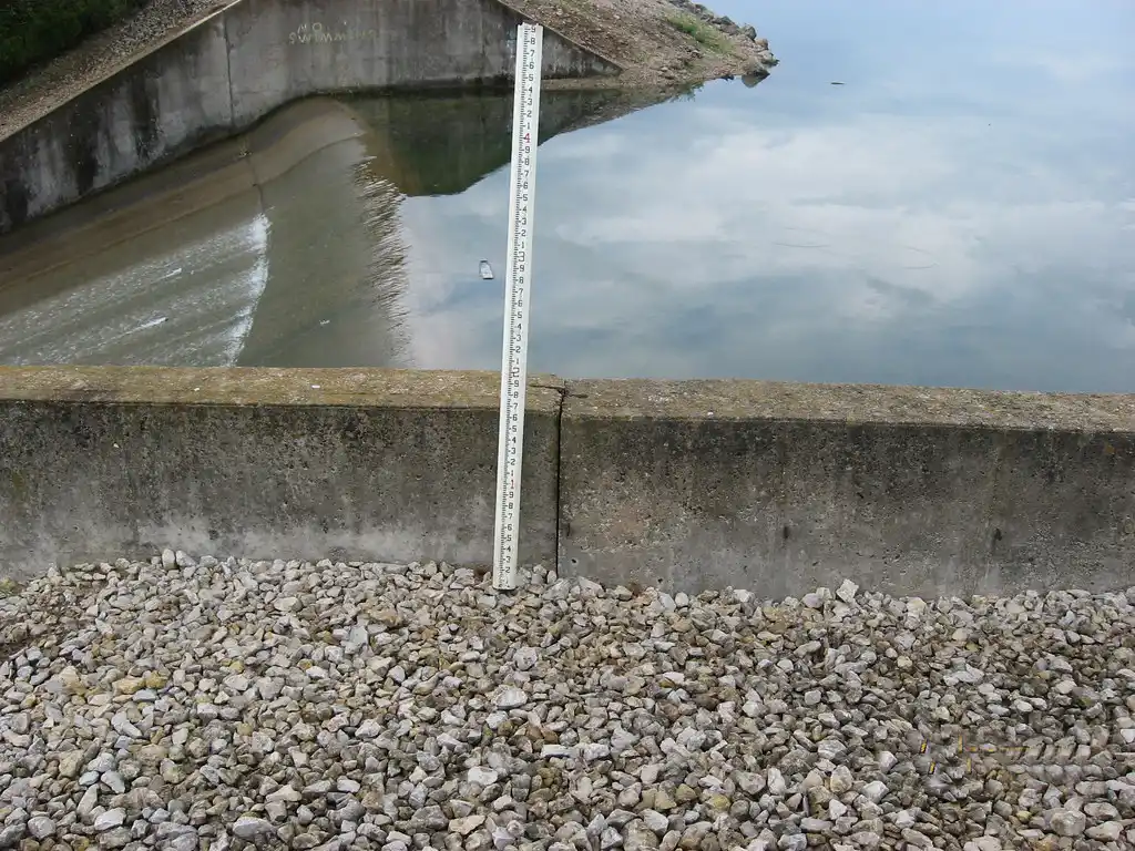 Hands marking wall measurements beside a tape measure and taped window opening