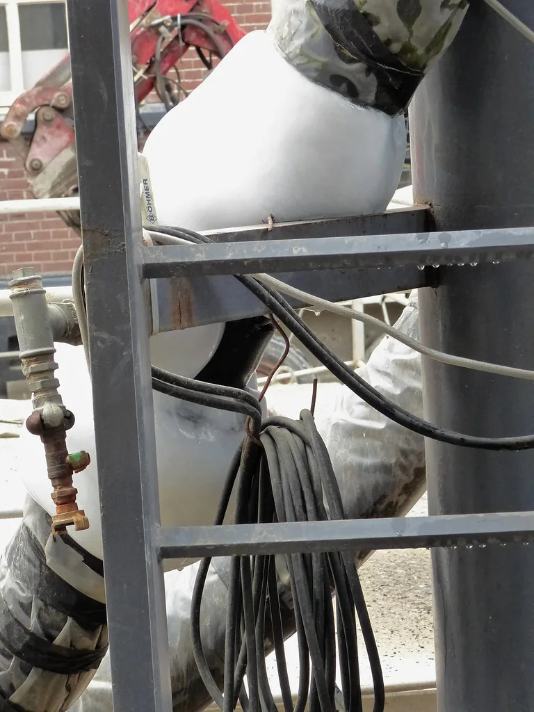 Close-up of a hand thawing a frozen water pipe with a hair dryer