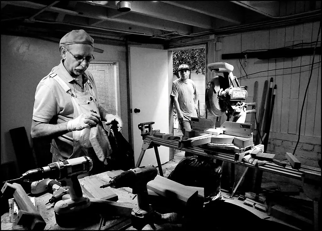 Festool Domino-style joiner on a woodworking bench with hands, hardwood boards, and pricing notes