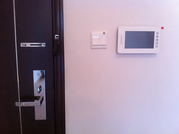 Hands engaging a door lock mechanism on the edge of a front door