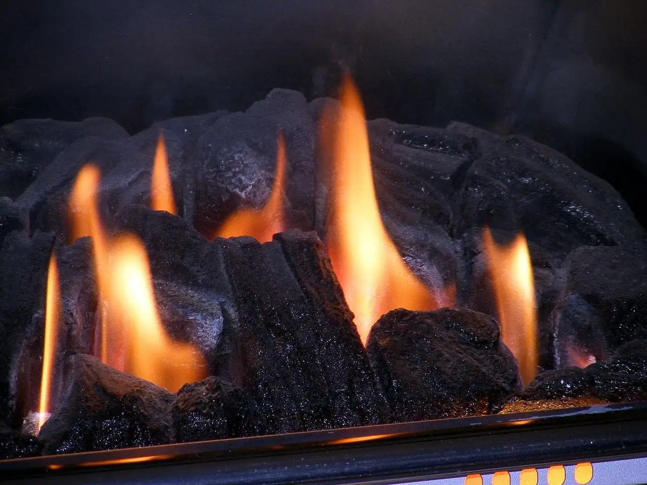 Homeowner checking a gas fireplace control area in a living room